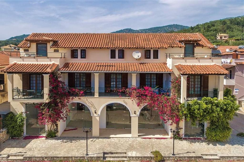 a large house with a courtyard with flowers at Villa Emily in Syvota