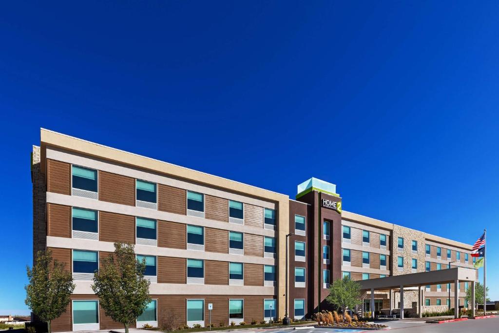 un gran edificio de oficinas con una bandera delante de él en Home2 Suites By Hilton Midland East, Tx, en Midland