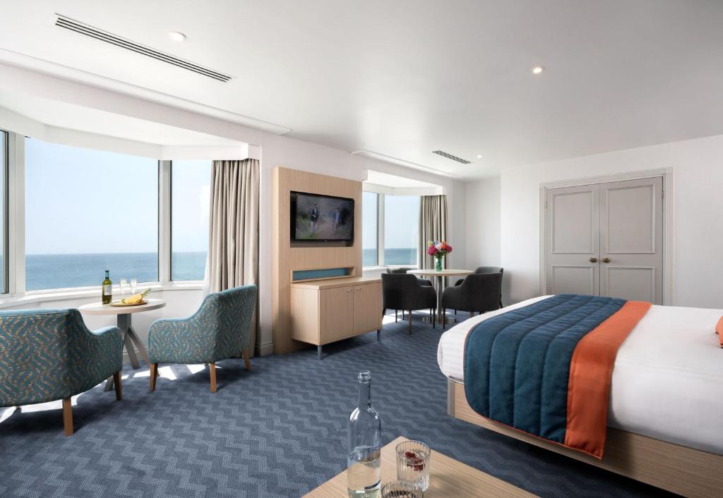 a hotel room with a bed and a table and chairs at Leonardo Royal Hotel Brighton Waterfront in Brighton & Hove
