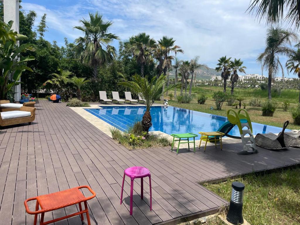 een patio met kleurrijke stoelen en een zwembad bij Villa Dada in M'diq