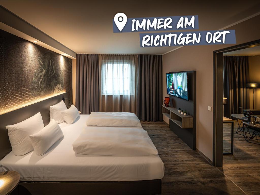a hotel room with two beds and a television at LOGINN Hotel Stuttgart Zuffenhausen in Stuttgart