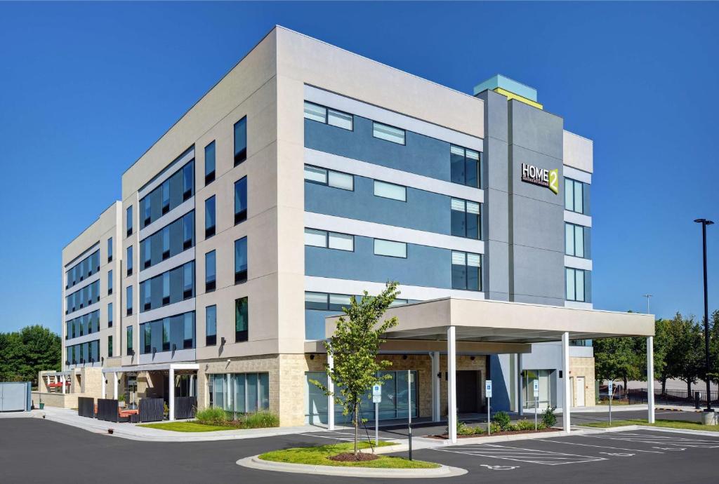 un gran edificio de oficinas con un cartel. en Home2 Suites By Hilton Raleigh North I-540, en Raleigh