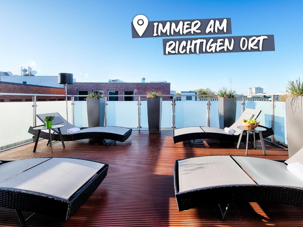 d'un balcon sur le toit avec des chaises et des tables. dans l'établissement ACHAT Hotel Bremen City, à Brême