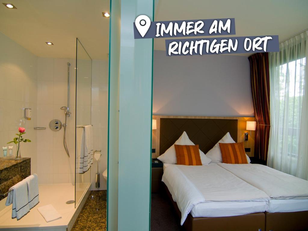a hotel room with a bed and a shower at ACHAT Hotel München Süd in Munich