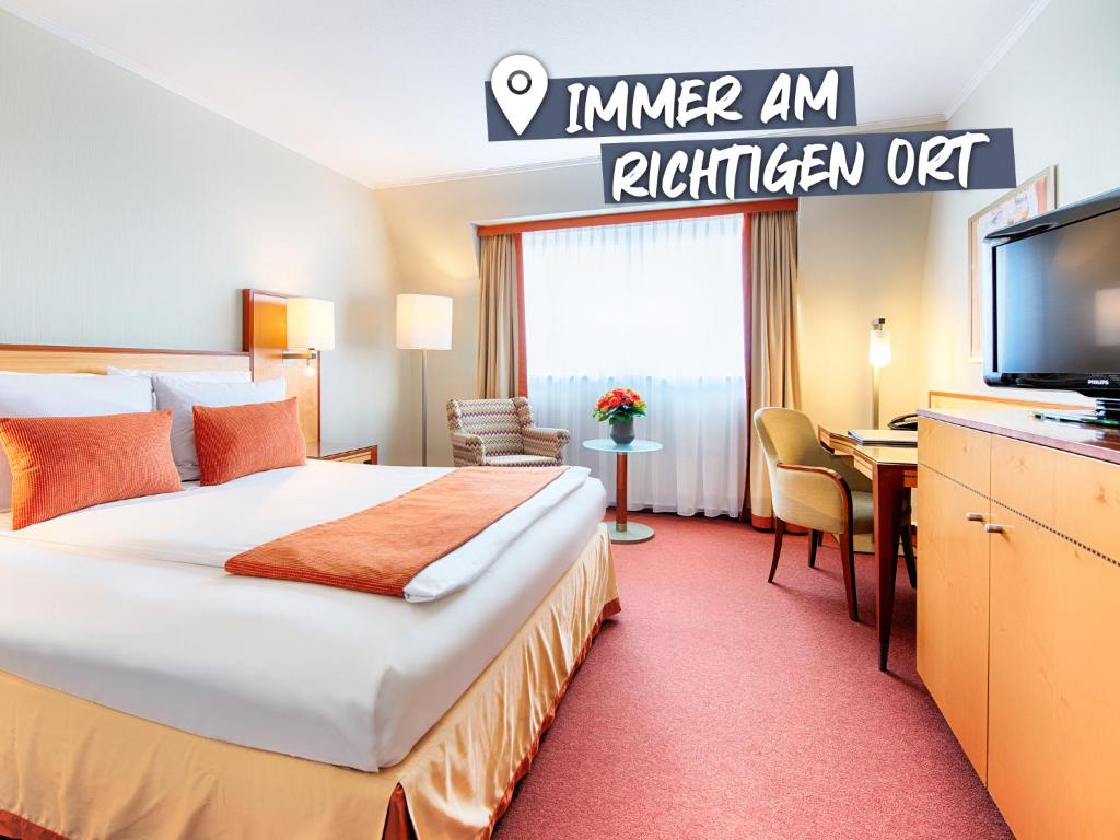 ein Hotelzimmer mit einem Bett und einem Flachbild-TV in der Unterkunft ACHAT Hotel Karlsruhe City in Karlsruhe