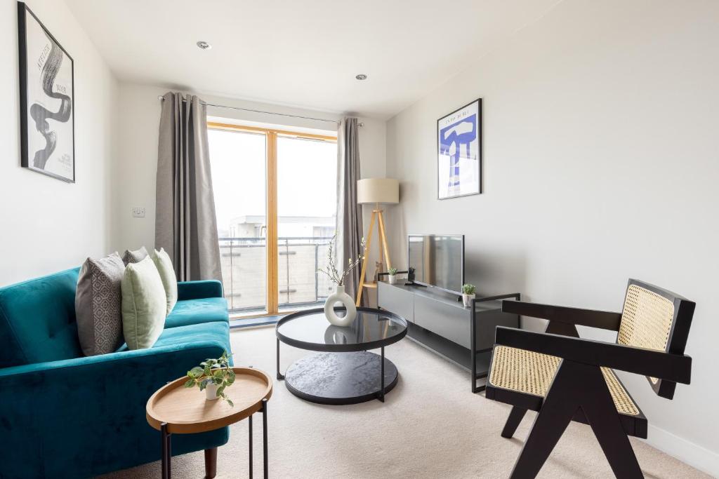 uma sala de estar com um sofá azul e uma mesa em The Wimbledon Collection em Londres