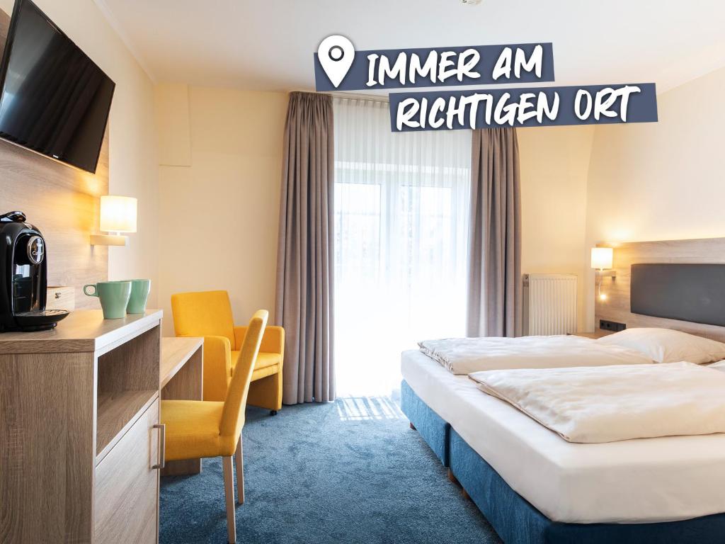 une chambre d'hôtel avec un lit et une télévision dans l'établissement ACHAT Hotel Lohr am Main, à Lohr