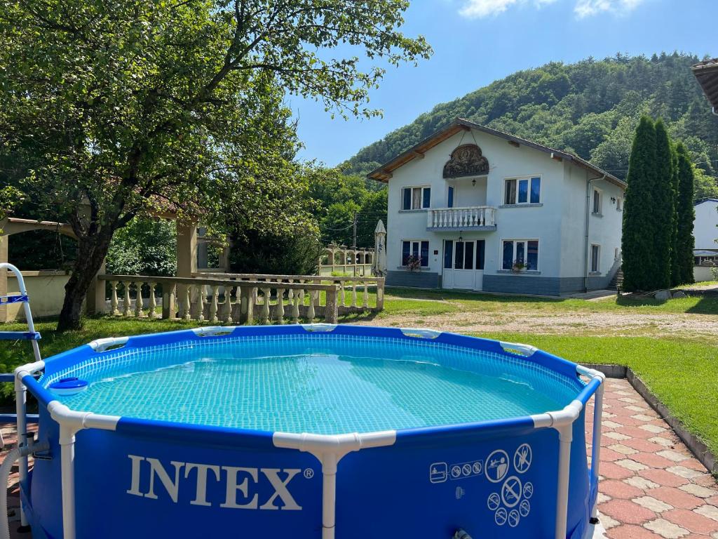 a pool in a yard with a house in the background at Vacation Home Yoanna in Tryavna
