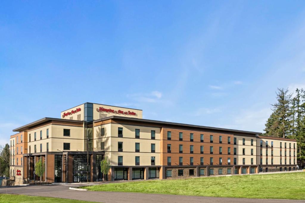 een groot bakstenen gebouw met een bord erop bij Hampton Inn & Suites Tigard in Tigard