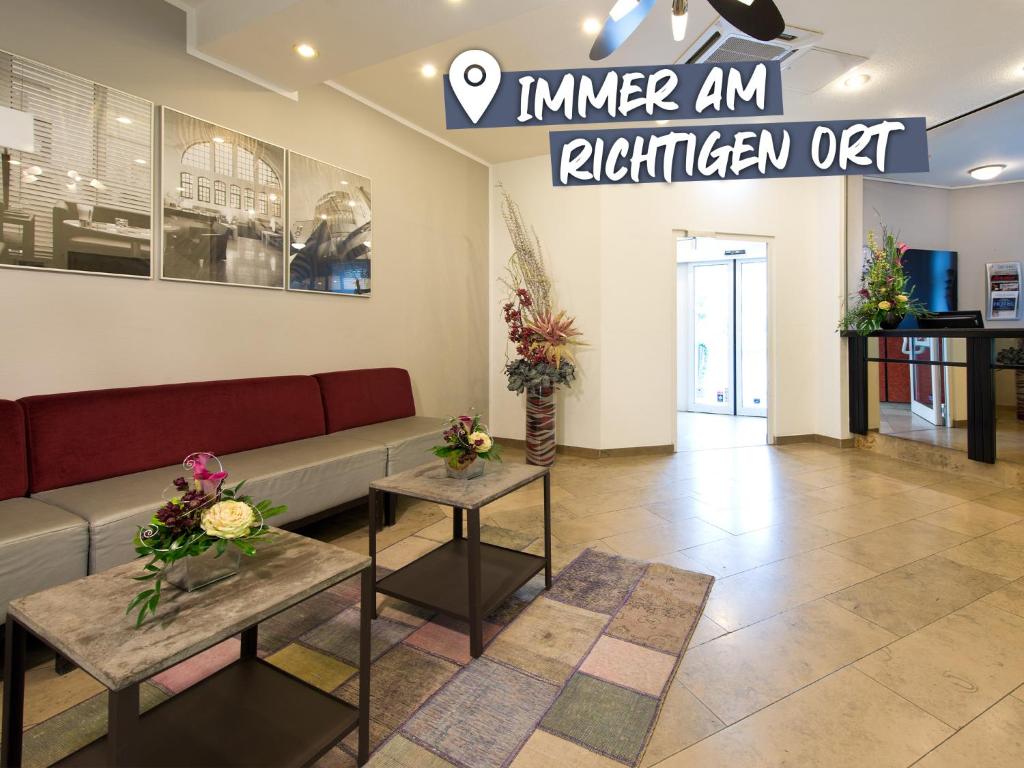 uma sala de espera com um sofá e duas mesas em ACHAT Hotel Frankenthal in der Pfalz em Frankenthal