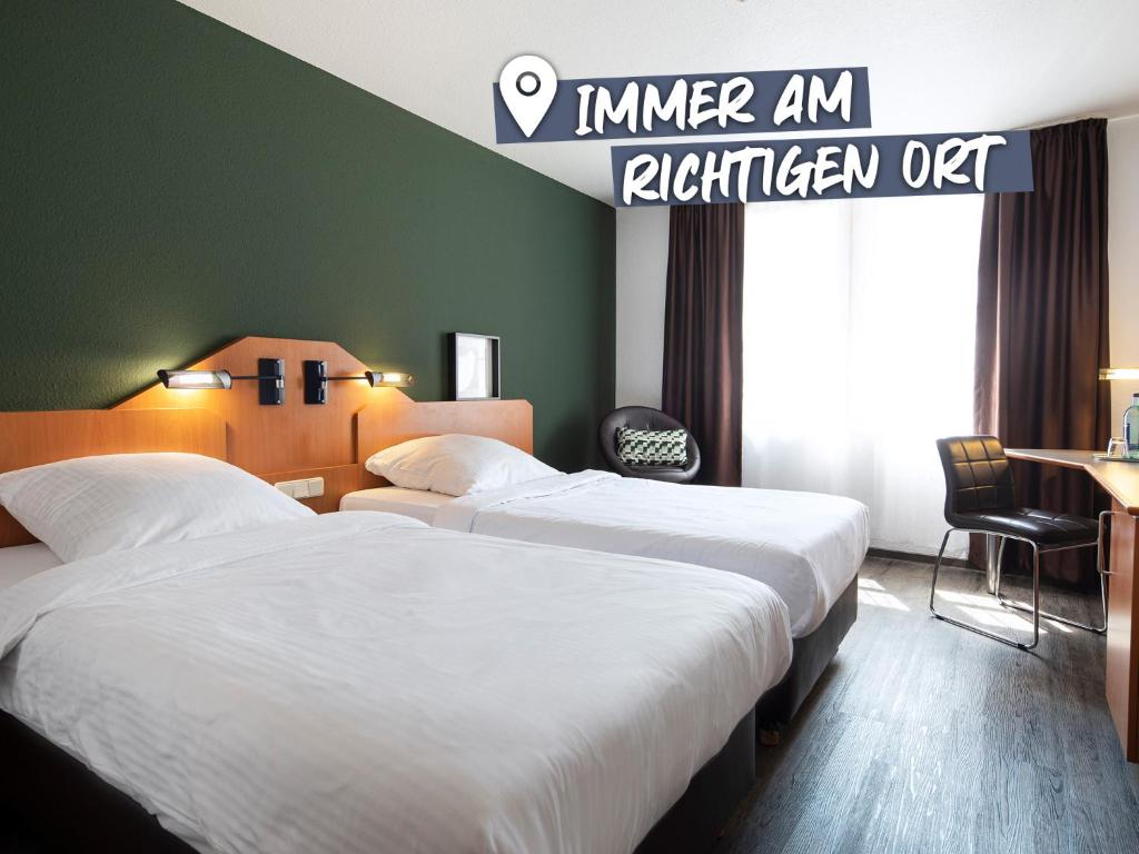 two beds in a hotel room with a sign at ACHAT Hotel Heppenheim in Heppenheim an der Bergstrasse