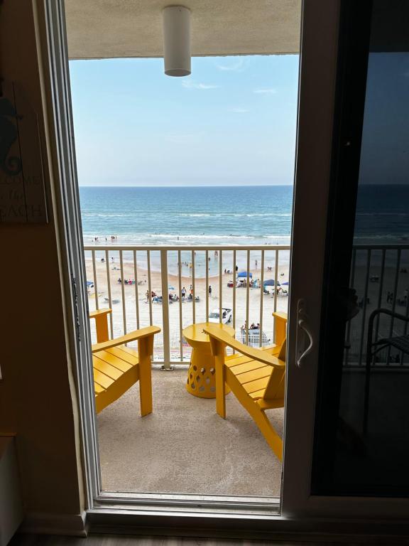 een kamer met uitzicht op het strand vanaf een balkon bij Oceanfront Oasis in Daytona Beach