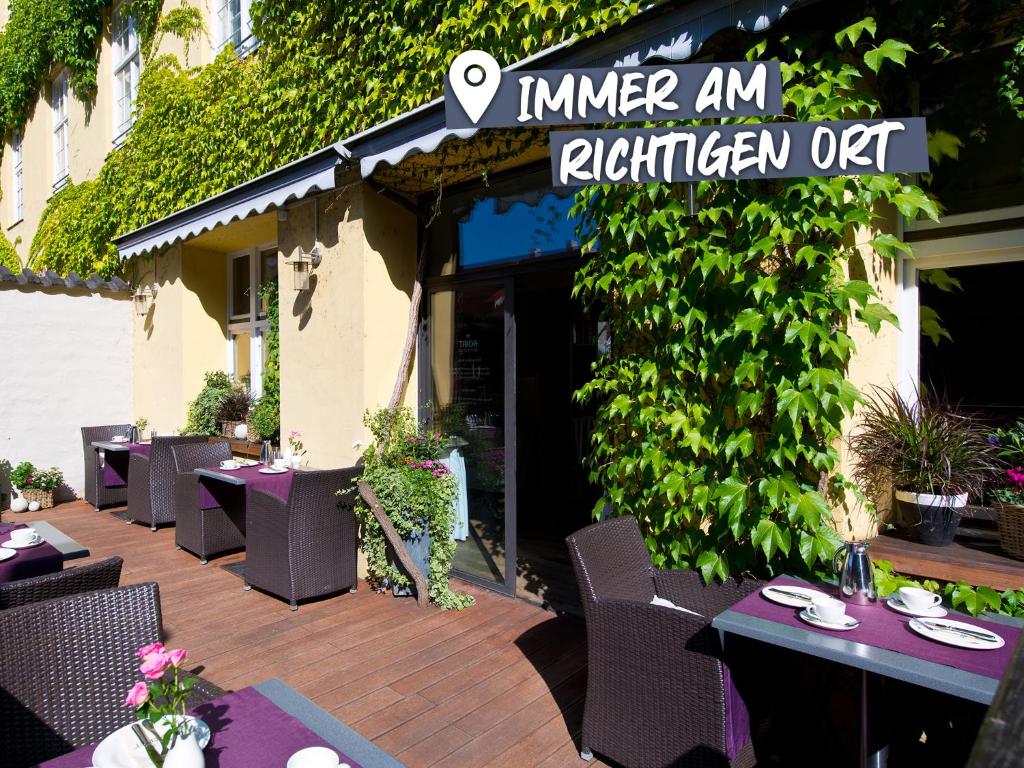 a restaurant with tables and chairs on a patio at ACHAT Hotel Regensburg Herzog am Dom in Regensburg