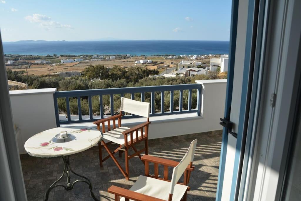 a balcony with a table and chairs and the ocean at MARINA apartment in Tinos Town