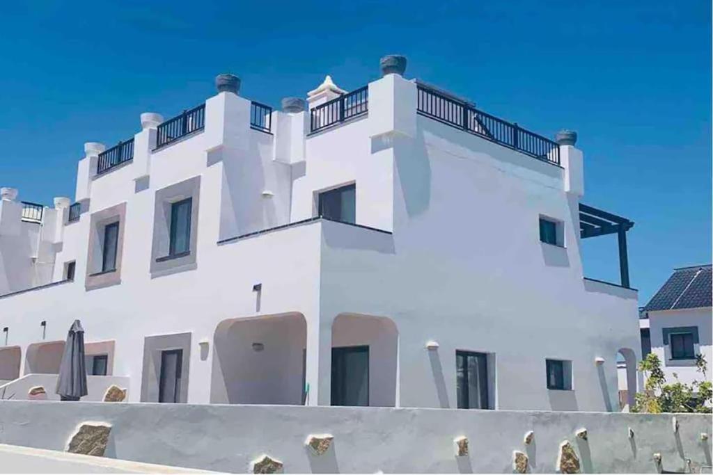 a white building with a balcony on top of it at Casa Mimi - your perfect family getaway in Corralejo