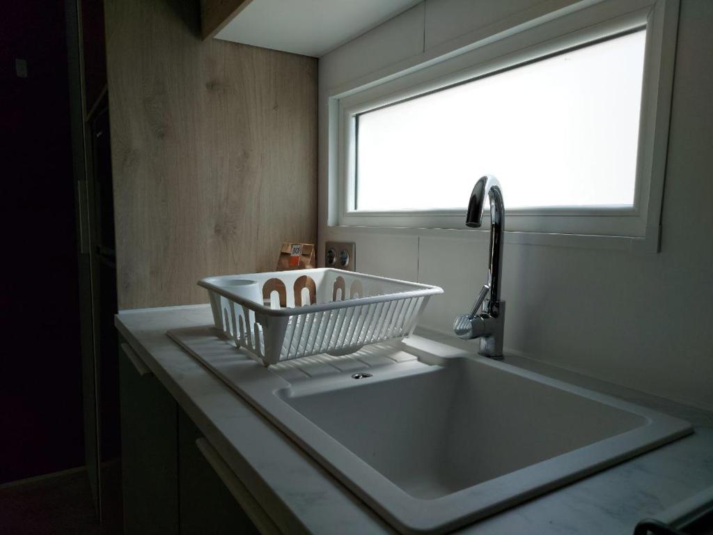 a bathroom sink with a basket on top of it at Camping Taimì in Marina di Massa