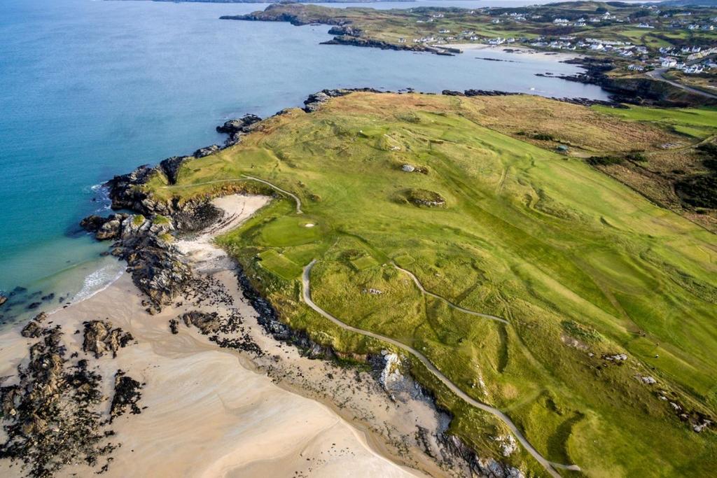 an aerial view of a golf course next to the ocean at Fairway Haven in Dunfanaghy