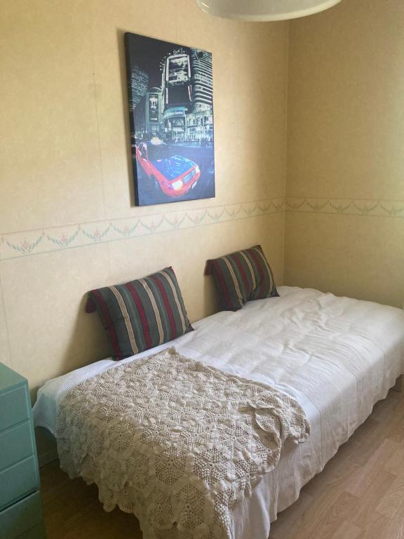 a bedroom with a bed and a picture on the wall at Hel rymlig villa uthyres in Skärblacka