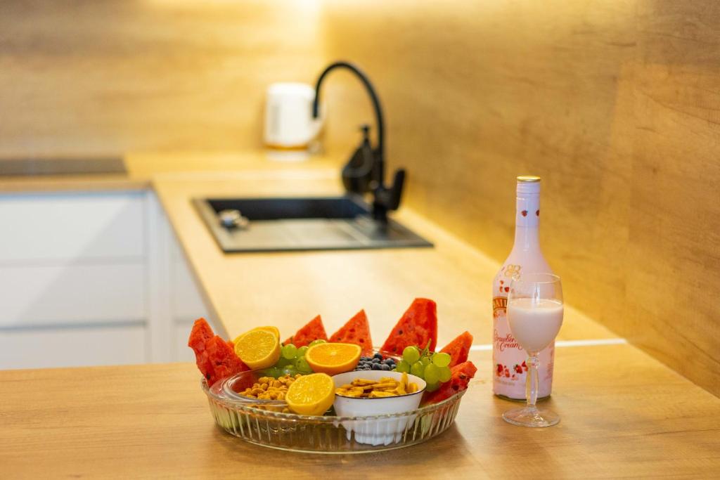 a bowl of fruit with a glass of wine and a bottle at Miranda's Place in Split