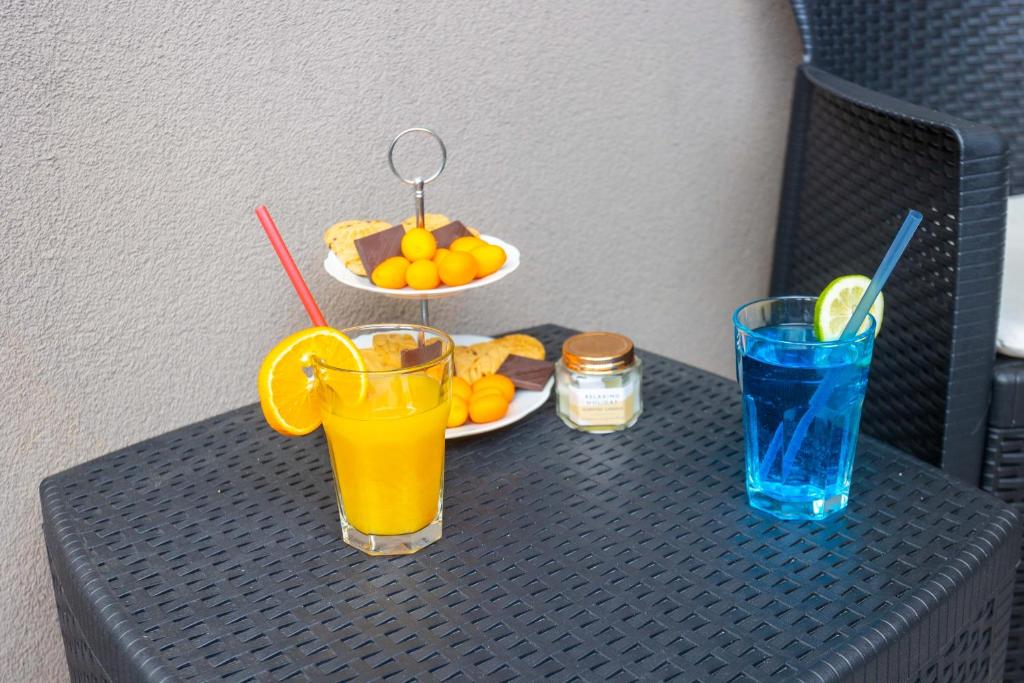 a table with two glasses of orange juice and a plate of fruit at Miranda's Place in Split