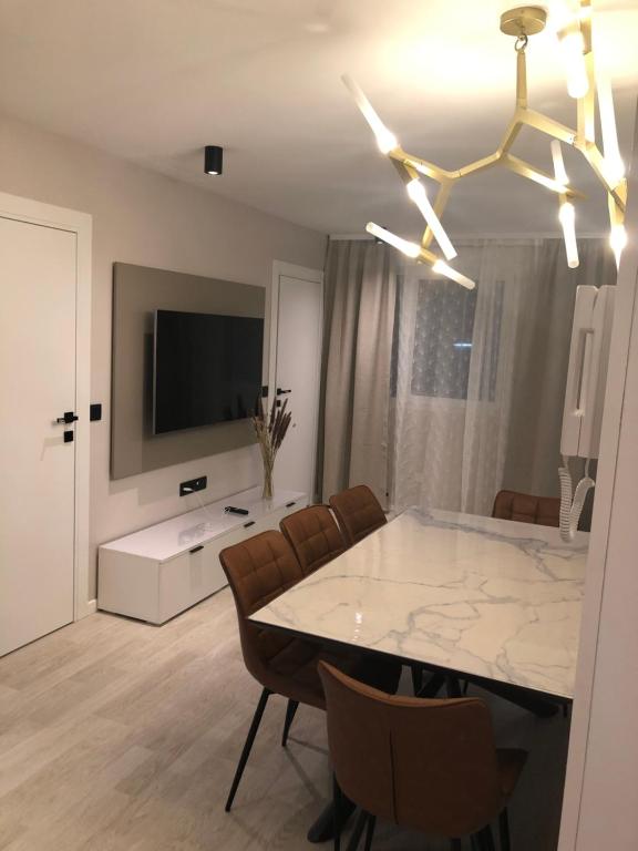 une salle à manger avec une table, des chaises et une télévision dans l'établissement EllA, à Nice