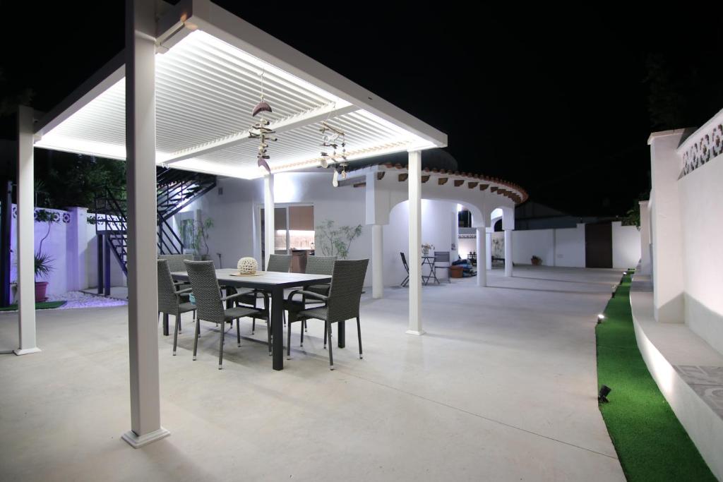 uma mesa de jantar e cadeiras sob um pavilhão à noite em Villa JAS San Juan em La Venteta