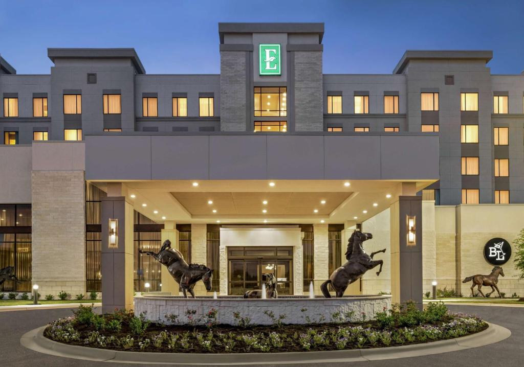a building with two statues of horses in front of it at Embassy Suites by Hilton Round Rock in Round Rock