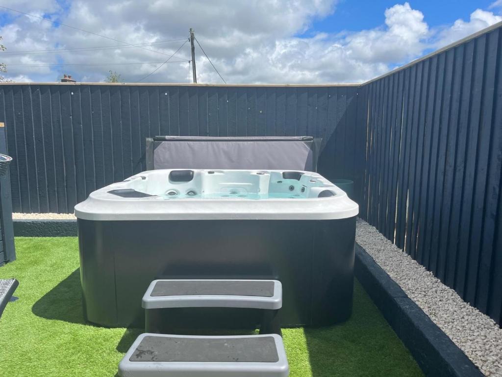 a bath tub sitting on the grass next to a fence at Number 1 Longstone Court in Haverfordwest