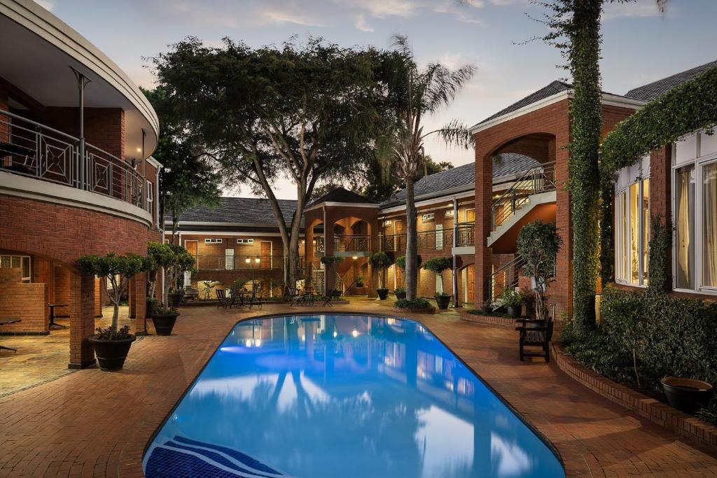 a swimming pool in the courtyard of a house at Premier Hotel Falstaff in Johannesburg