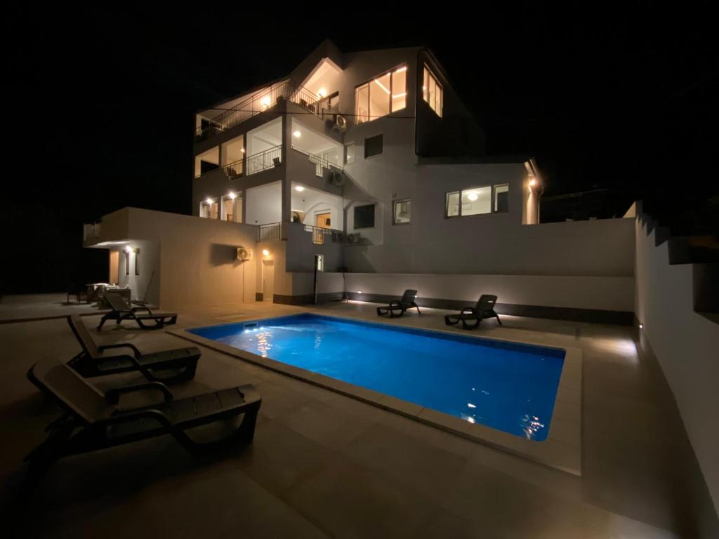 a swimming pool in front of a house at night at villa Ana in Preko