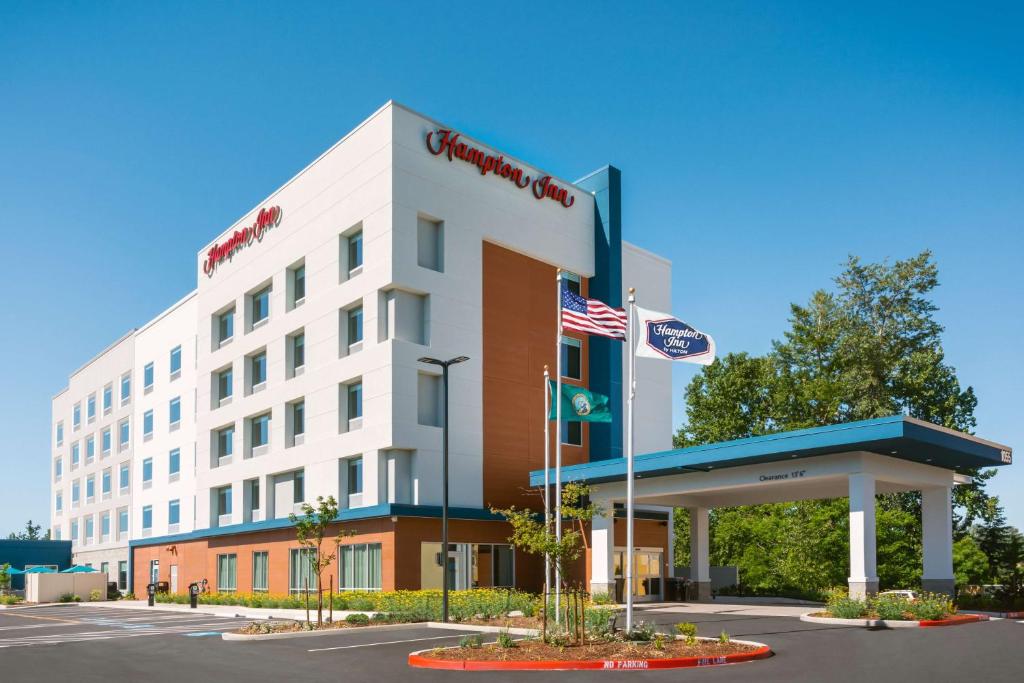 an exterior view of a hotel with an american flag at Hampton Inn Bellingham Airport, WA in Bellingham