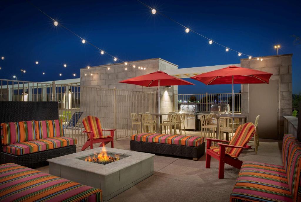 un patio con mesas, sillas y una hoguera en Home2 Suites By Hilton Phoenix Avondale, Az en Avondale