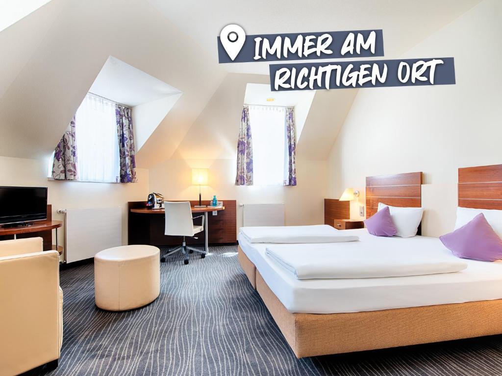 ACHAT Hotel Wiesbaden City في فيسبادن: غرفة فندقية بسريرين ومكتب
