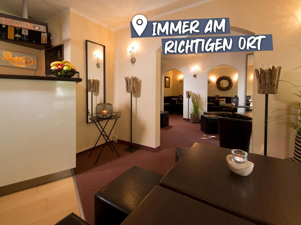 a living room with a table and a kitchen at ACHAT Hotel Dresden Elbufer in Dresden