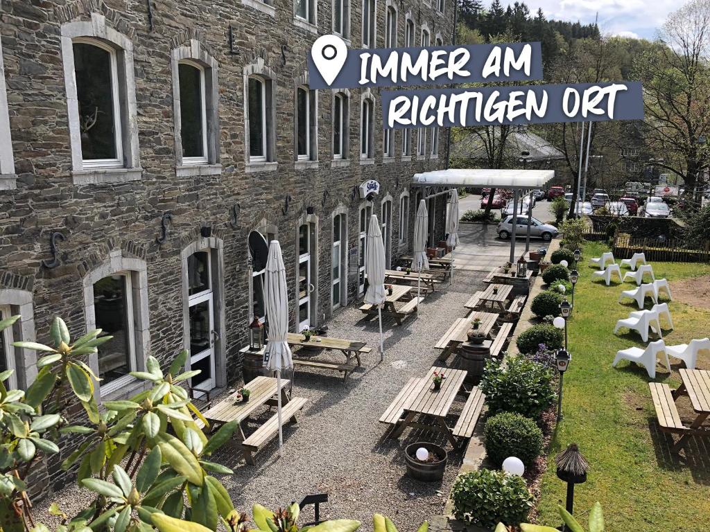 un groupe de bancs devant un bâtiment en briques dans l'établissement ACHAT Hotel Monschau, à Monschau