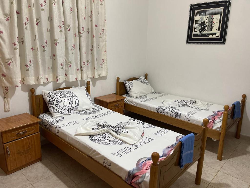 2 Einzelbetten in einem Zimmer mit Vorhang in der Unterkunft Gerea's Holiday House in Durrës