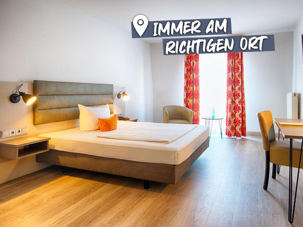 a bedroom with a bed and a table at ACHAT Hotel Zwickau in Zwickau