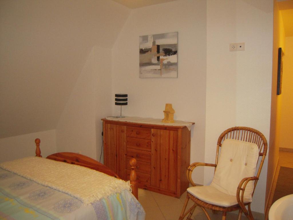 um quarto com uma cama, uma cadeira e uma cómoda em Bel appartement de charme de 70 m2 em Thannenkirch