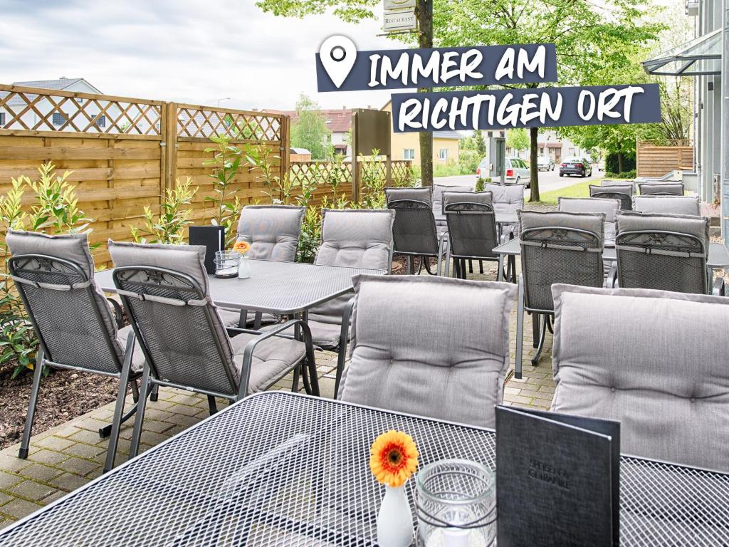 szereg stołów i krzeseł na patio w obiekcie ACHAT Hotel Leipzig Messe w Lipsku