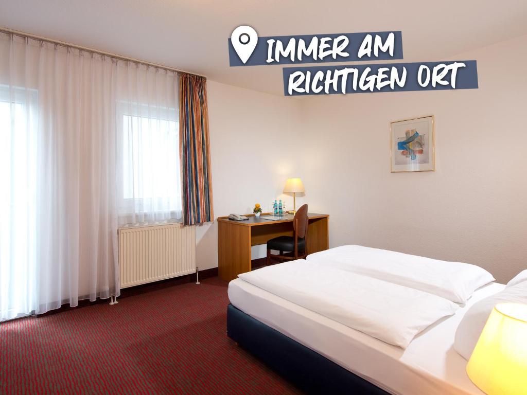 Habitación de hotel con cama y escritorio en ACHAT Hotel Darmstadt Griesheim en Darmstadt