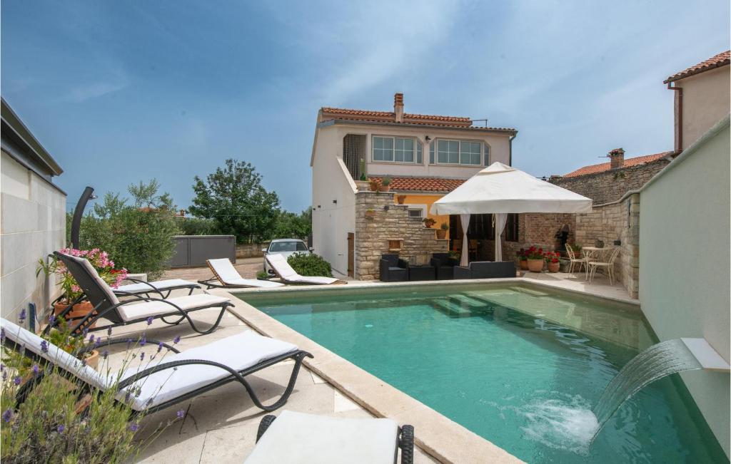 una piscina con sedie e ombrellone accanto a una casa di Holiday Home Kavran Ii a Kavran