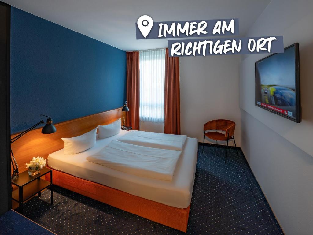 a hotel room with a bed and a flat screen tv at ACHAT Hotel Dresden Altstadt in Dresden