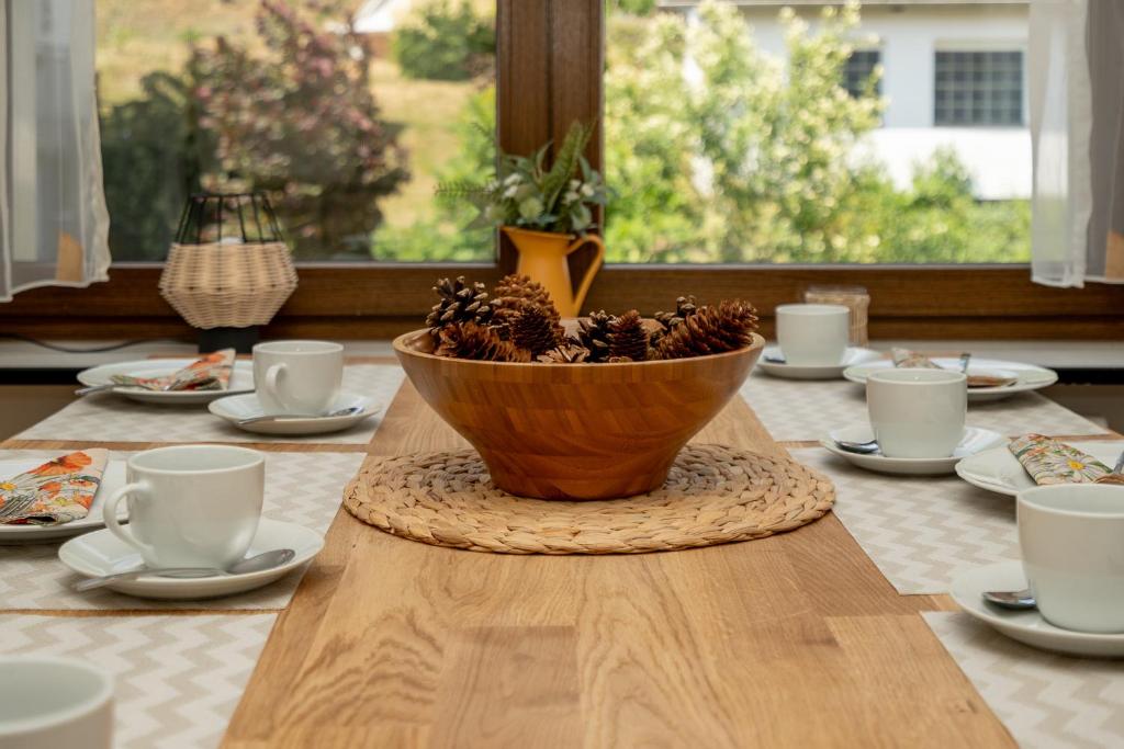 una mesa de madera con un cuenco de piñas. en Ferienwohnung Suhl/ Wichtshausen, en Suhl