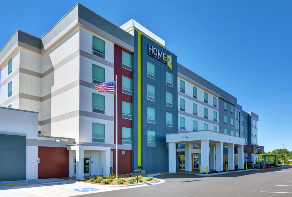 an exterior view of a hotel with an american flag at Home2 Suites By Hilton Bentonville Rogers in Bentonville