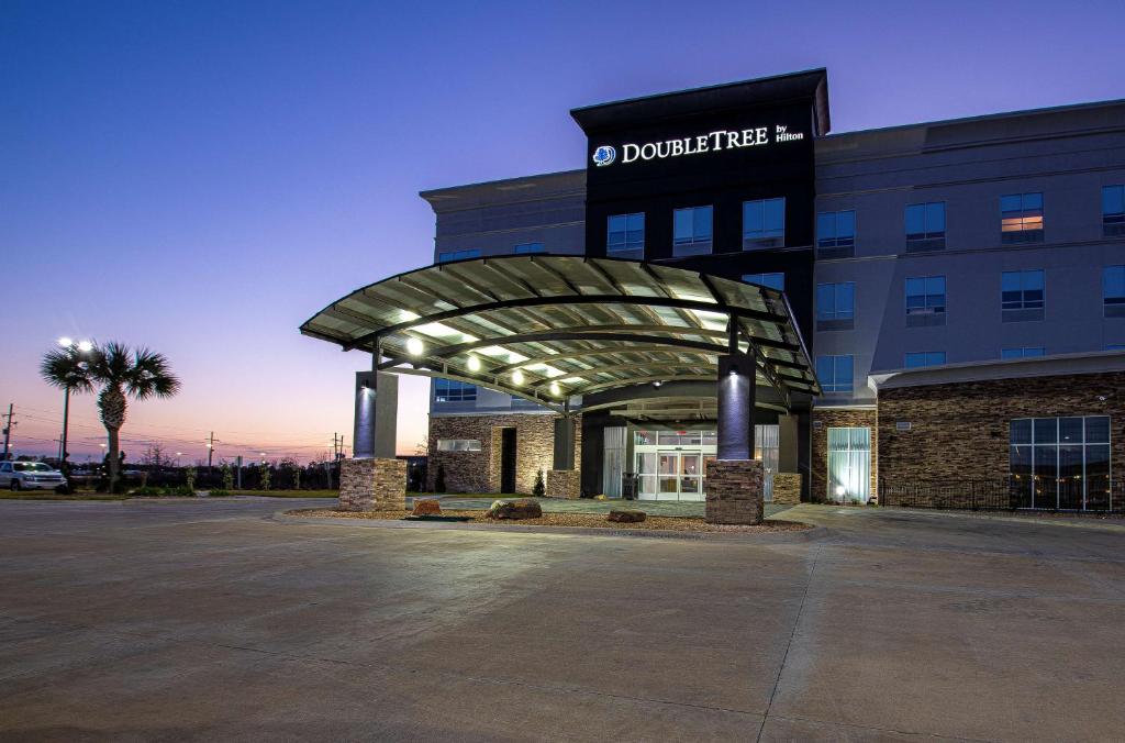 a building with a sign on the front of it at Doubletree Sulphur Lake Charles in Sulphur