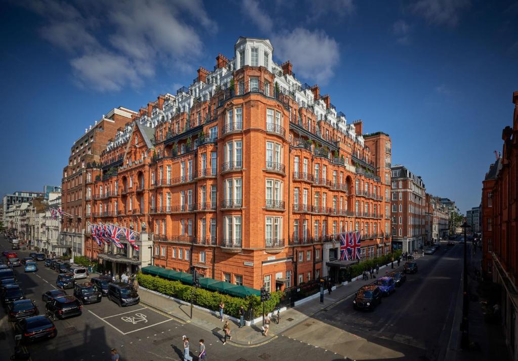 um grande edifício de tijolos vermelhos numa rua da cidade em Claridge's em Londres