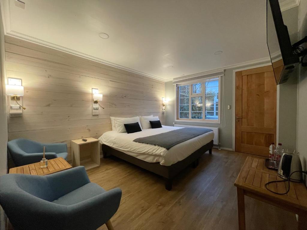 1 dormitorio con 1 cama, 1 sofá y 1 silla en Hostal Boutique Puerta Roja en Punta Arenas