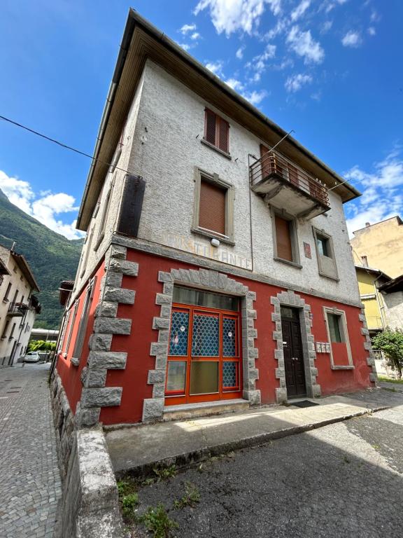 ein rot-weißes Gebäude an der Straßenseite in der Unterkunft Casa Grazia in Lovero Valtellino