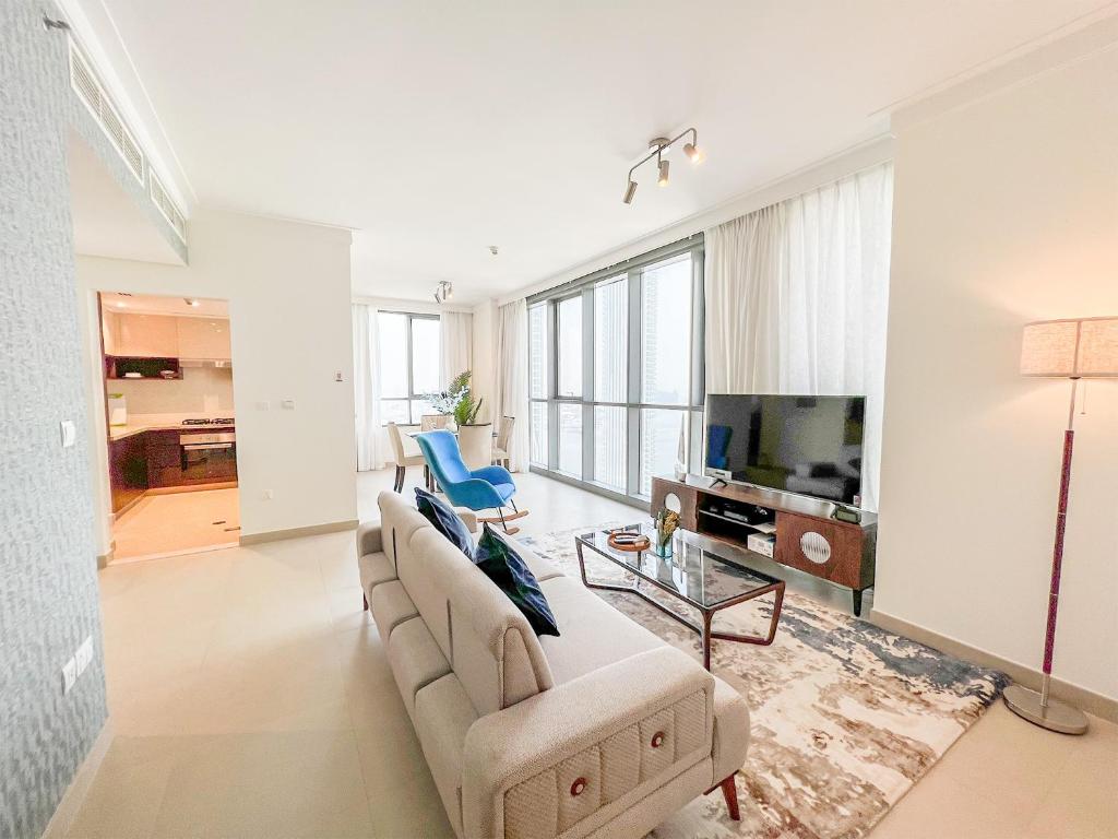 - un salon avec un canapé et une télévision dans l'établissement Cosmos Living - Dubai Creek Harbour, à Dubaï