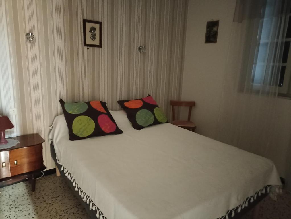 um quarto com uma cama com duas almofadas em T2 à 30 mn de la mer, au pied des montagnes Céret em Céret